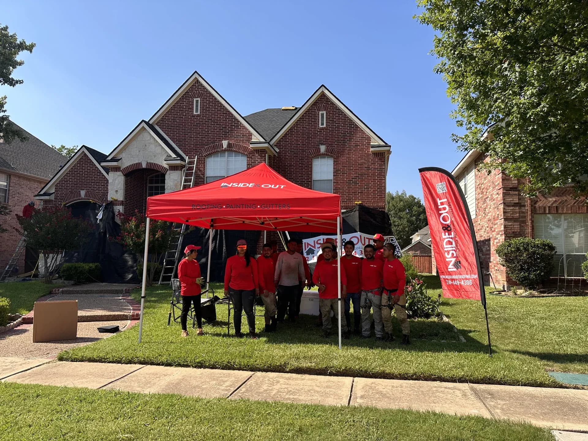 Team standing in front of a house